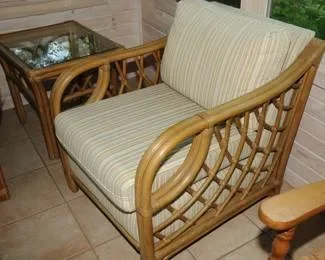 Rattan & cane accent arm chair with curved arms and beige striped cushion